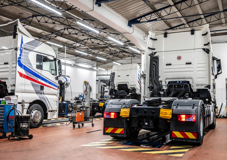 Trucks in a large maintenance garage.